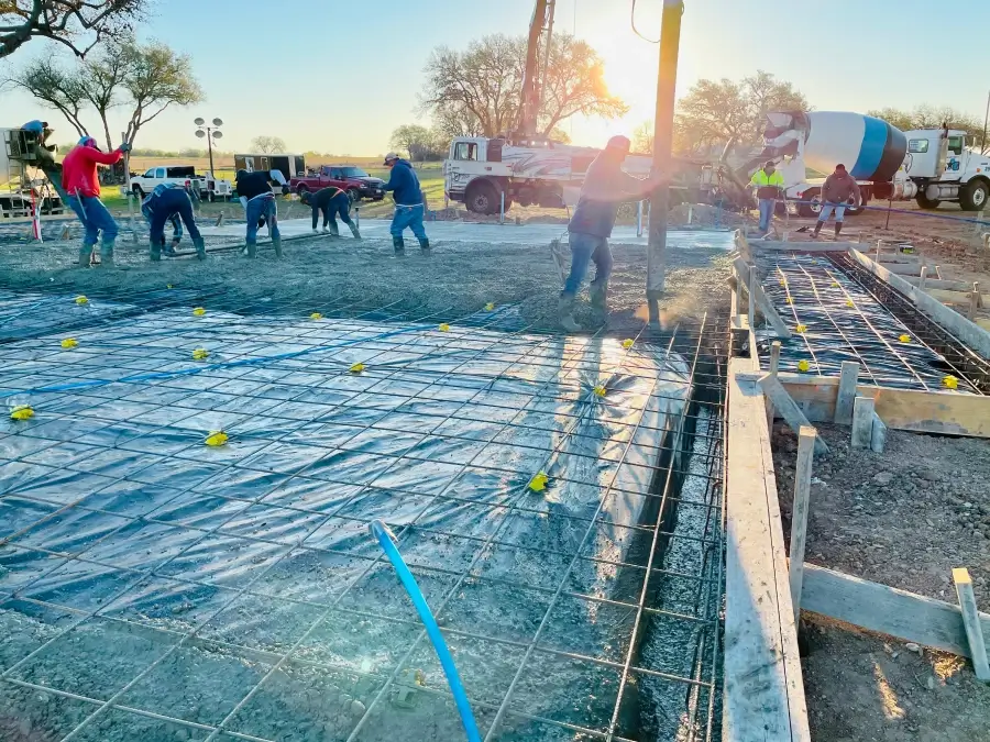 Construction workers pouring concrete with sunlight.